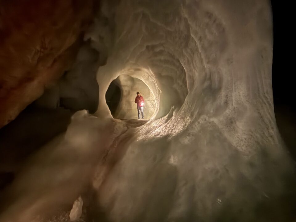 Eisriesenwelt Werfen: De grootste ijsgrot ter wereld in Oostenrijk 1 Bezoeker met lamp in een grote ijsgrot met golvende ijswanden