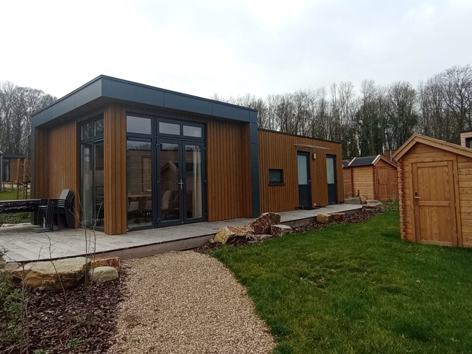 Resort Namur Nature Review: Landal Getaway in Gesves 1 Houten vakantiehuisjes rond een modern chalet met terras, grindpad en grasveld