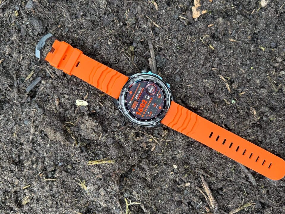 Review: KKTICK TANK T5 Smartwatch 1 Oranje smartwatch met rond scherm ligt op donkere bosgrond